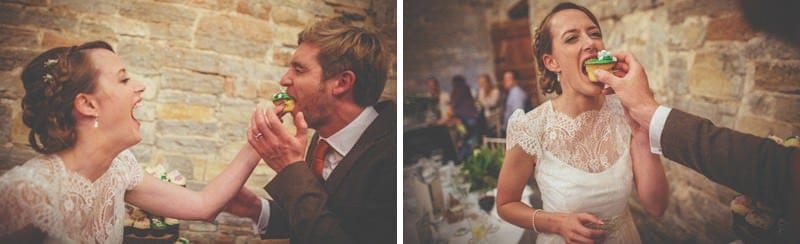 The bride and groom place cupcakes into each others mouths