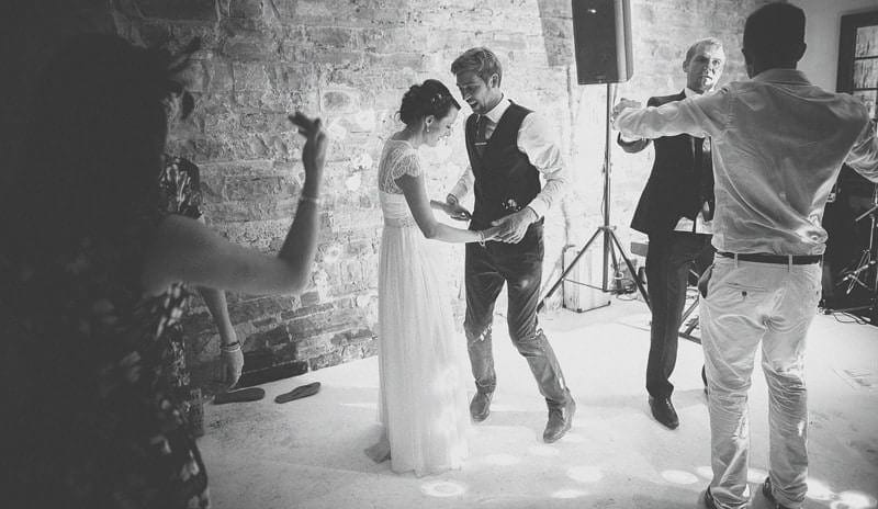 The bride and groom dancing with friends and family on the dancefloor at Almonry Barn
