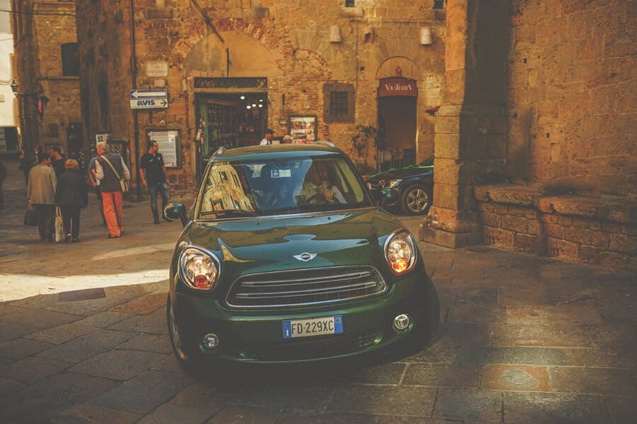 The wedding car drives through the old town of Volterra