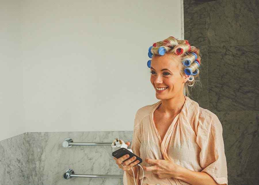 The bride smiles in her hotel room