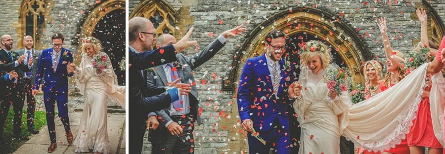The bride and groom have confetti thrown on them as they leave the Church of St Michael and All Angels, Somerton