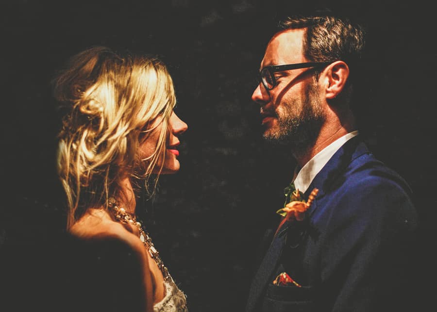 The bride and groom look at each other in the back garden at Sharpham Park