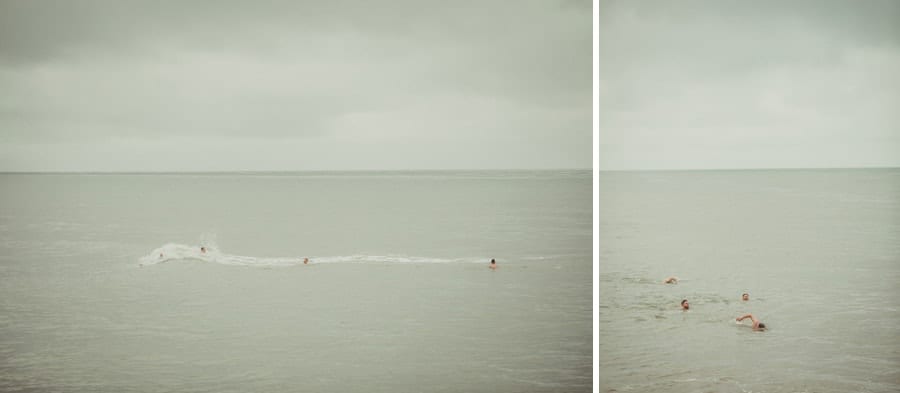A wave catches the men swimming in the sea at Lyme Regis in Dorset