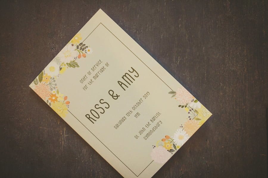 Ross and Amy's wedding invitation on a wooden table