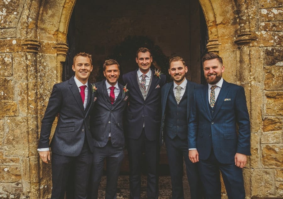 The groom with his best man and ushers pose for a photograph outside the front of the church