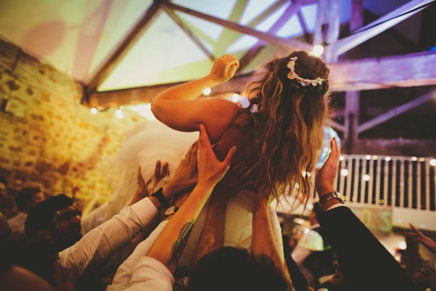 Wedding guests raise the bride in the air on the dance floor