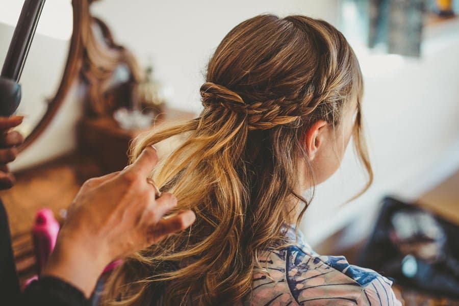 The hairdresser attends to a bridesmaids hair
