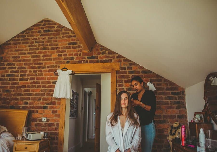 The hairdresser attends to the back of the brides hair