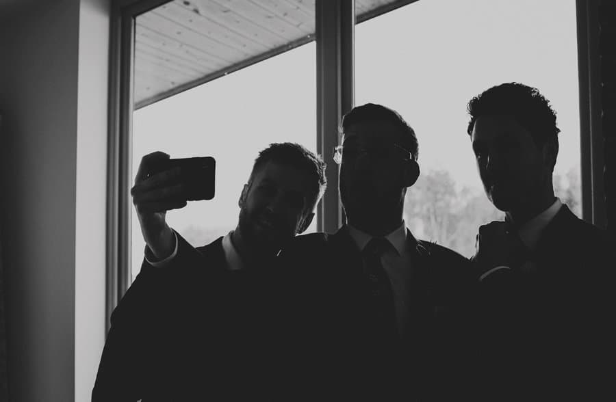 Ushers take a photograph next to the window in their apartment