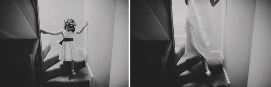 The flowergirl and the bride walk down the staircase