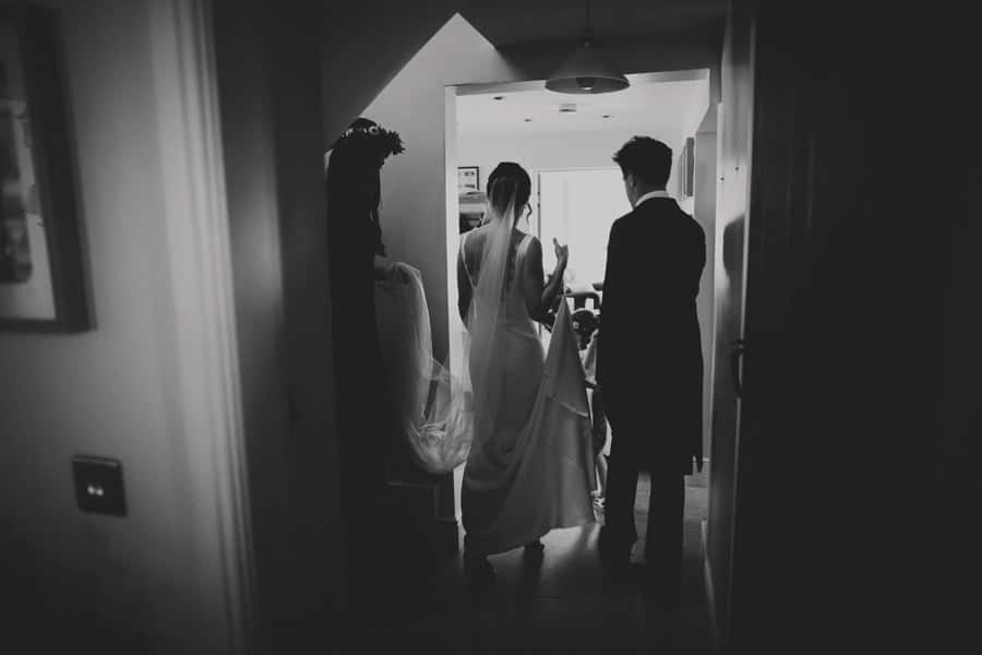 The bride and her brother walking through the house at Mill farm