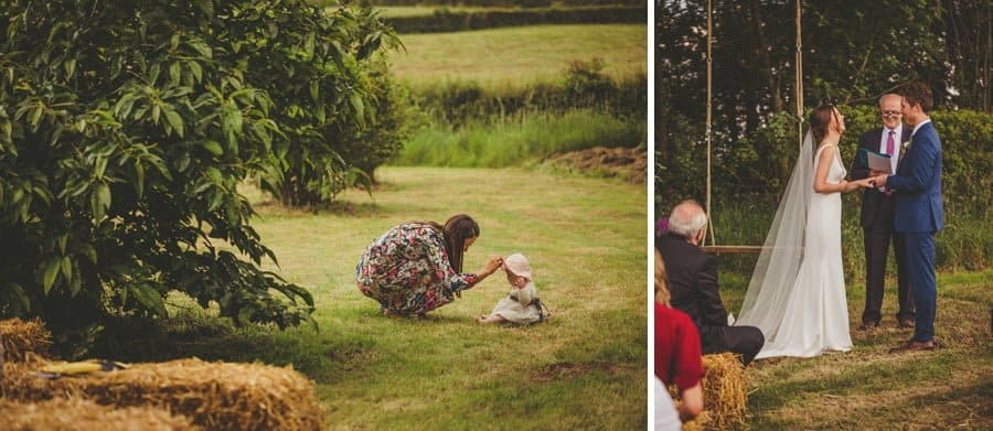 A mother attends to her baby's hat sat on the grass