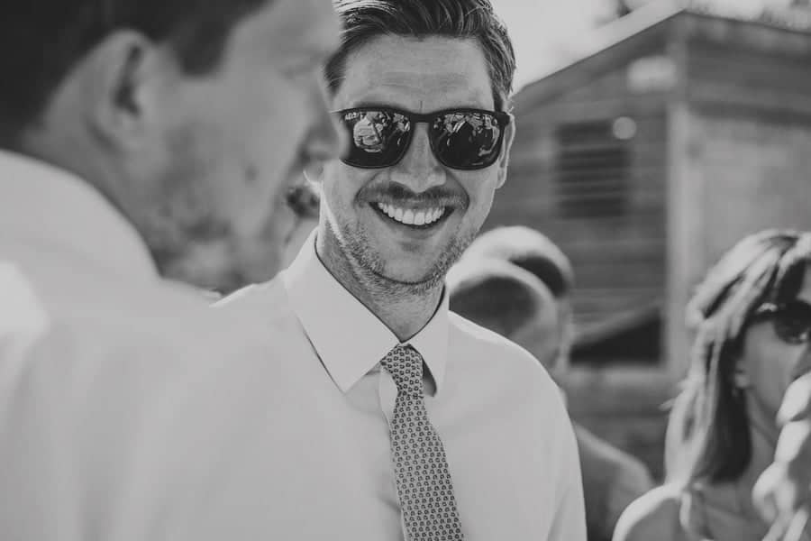 A wedding guest laughs with a friend