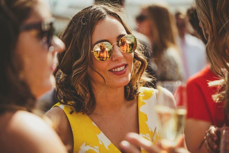 A wedding guest listens to a story told by a bridesmaid