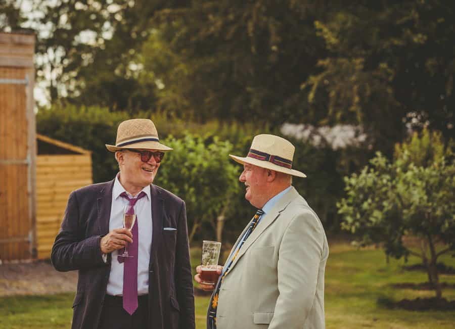 Wedding guests laugh and joke on the lawn