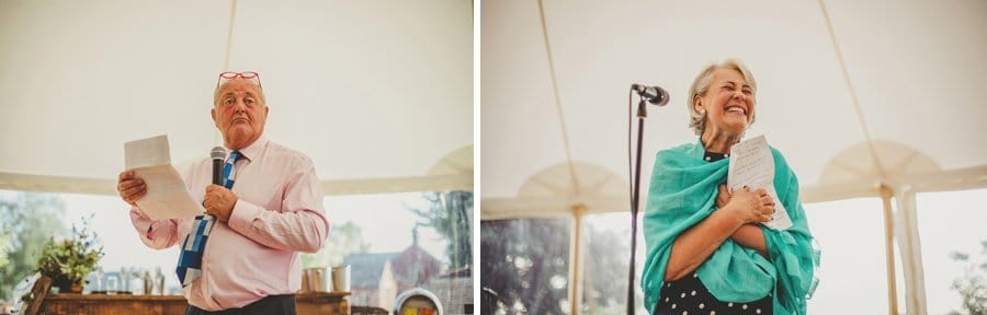 The brides father looks towards the bride and groom and the brides mother laughs