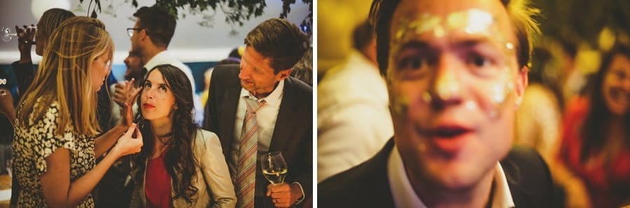 A lady paints a wedding guests face with glitter and an usher laughs