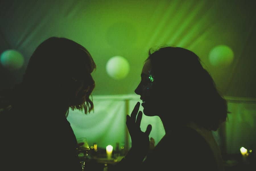 Painting glitter on the lips of a bridesmaid in in the marquee