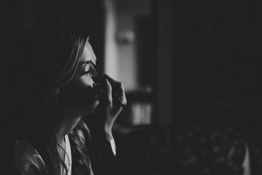 The make up artist paints the brides eyebrows