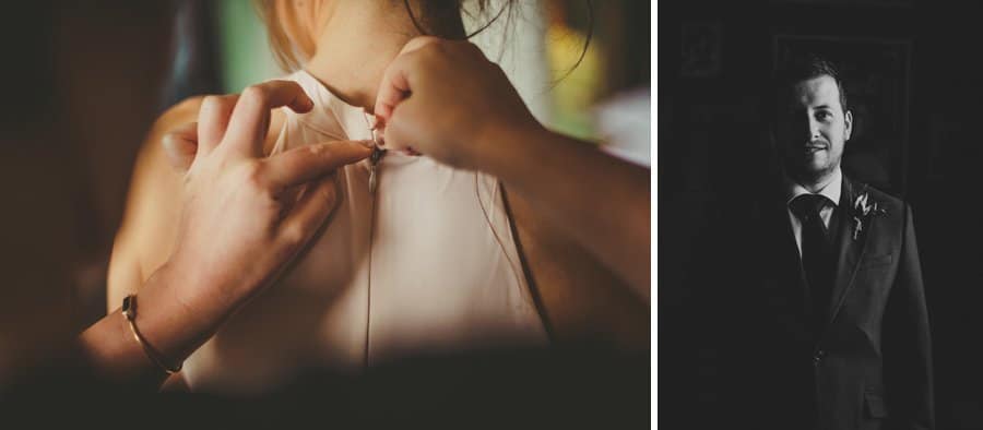 A bridesmaid buttons up the back of a dress and an usher poses for a photograph next to the window