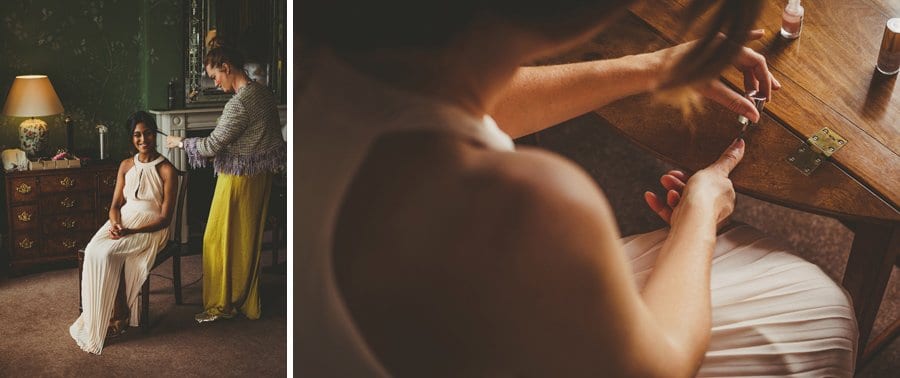 A bridesmaid paints her nails with nail varnish on a wooden table
