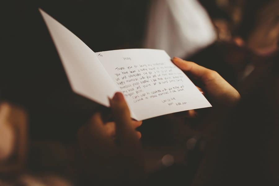 A bridesmaid reads a thank you card given to her by the bride