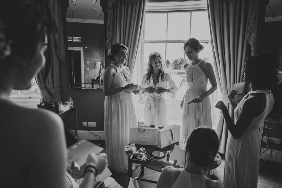 The bride and her bridesmaids laugh and joke with each other