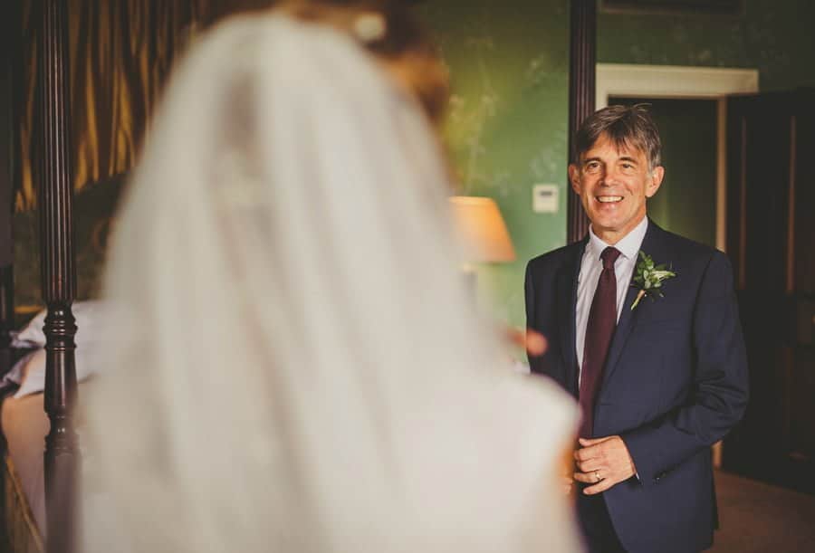 The brides father arrives in the brides room and sees his daughter in her wedding dress for the first time