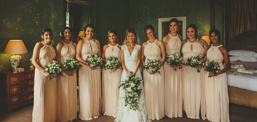 The bride and her bridesmaids pose for a photograph in the main bedroom at Stubton Hall