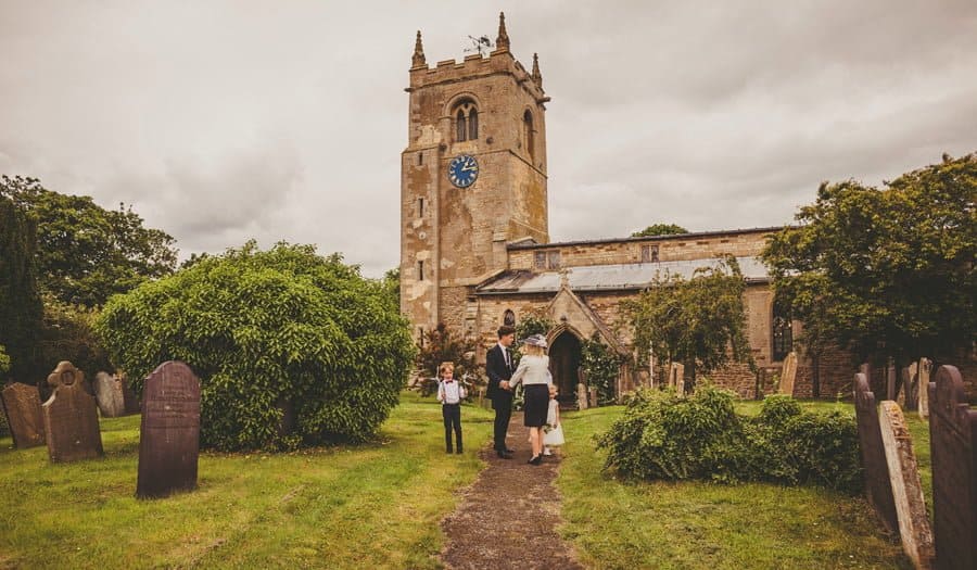 The brides brother greets his mother outside the church
