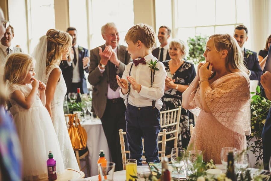 The bride and groom enter the main room as friends and family congratulate them