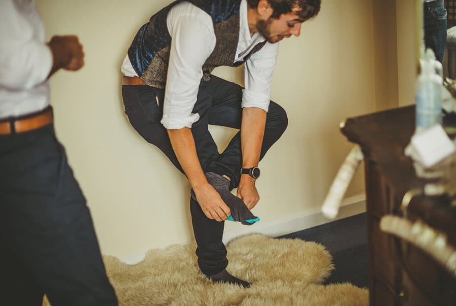 The groom bends over and puts his socks on