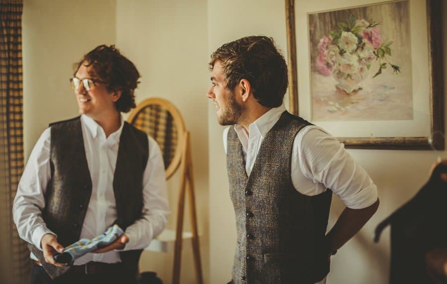 The groom laughs with ushers as they get ready