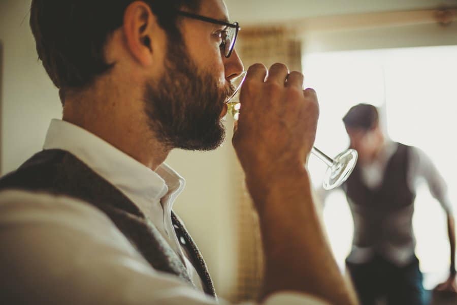 The best man sips a glass of champagne