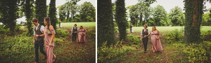 Bridesmaids and ushers walk into the woods for the wedding ceremony