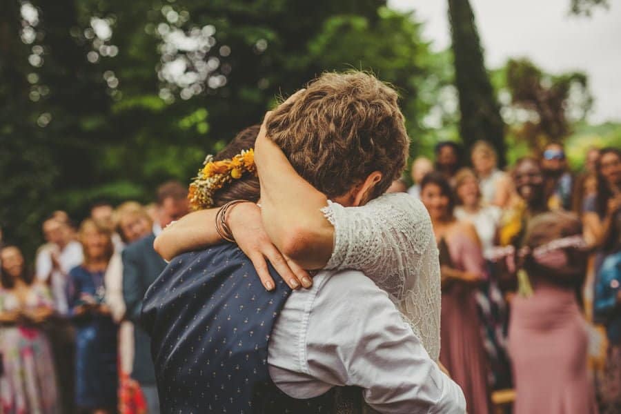 The bride holds the groom in her arms