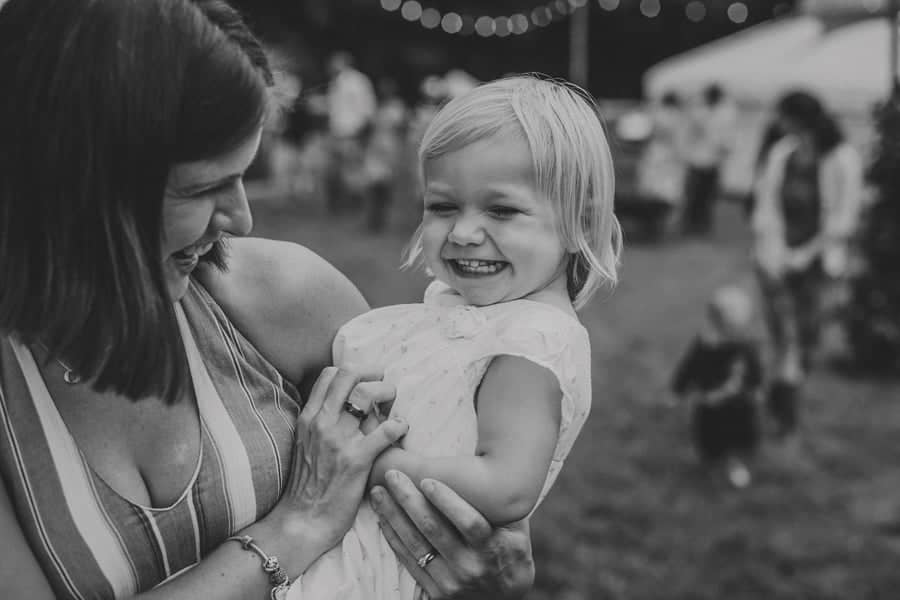 A little girl laughs with her mother