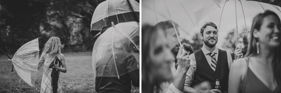 Wedding guests stand under umbrellas in the school field