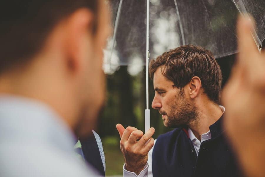 A man holding his umbrella in the school field