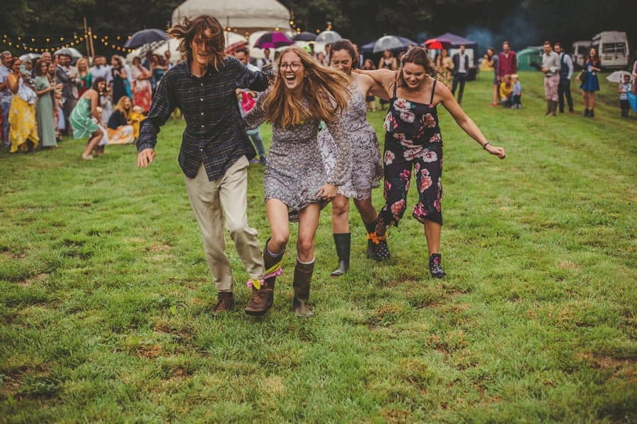 Wedding guests running around the school field with scarves tied to their ankles