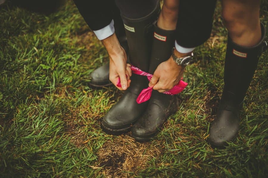 A wedding guest ties a scarf around the ankles of his partner and himself