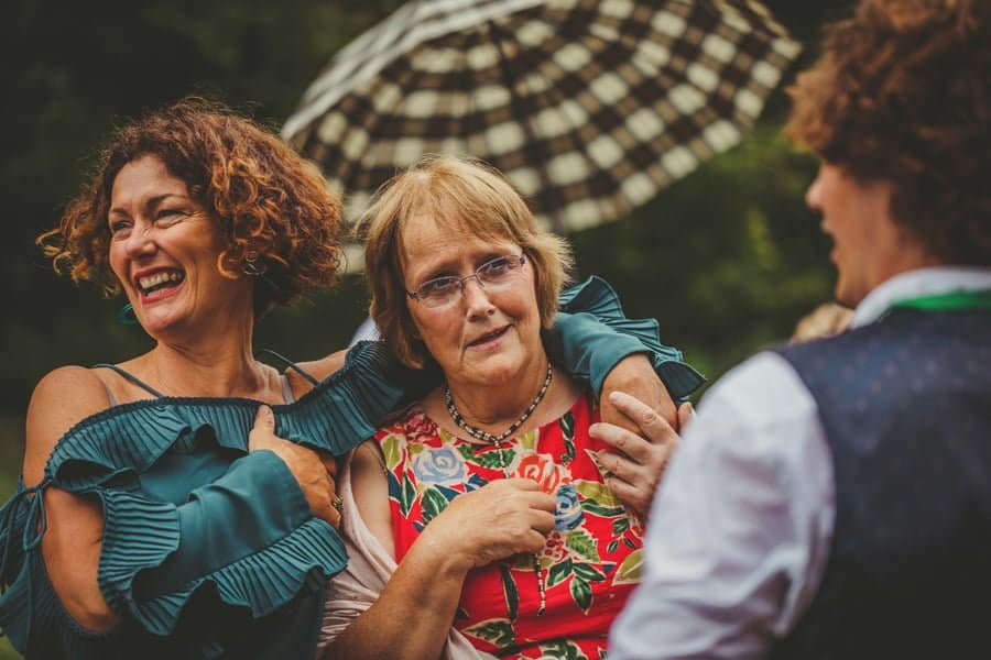Wedding guests laugh and joke to each other as they watch the games