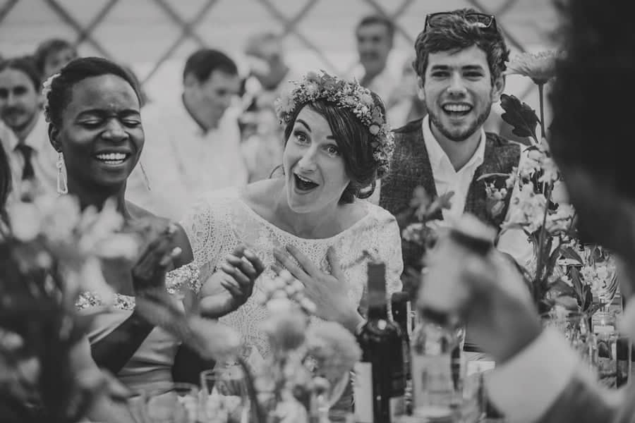 The bride and groom laugh as they listen to one of the bridesmaids speeches