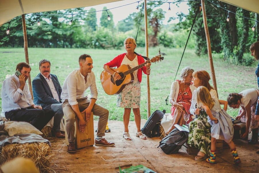 Wedding guests sing along to an Irish song under the canopy of the tent
