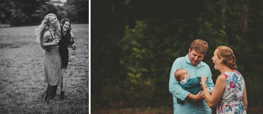 A man holds his baby, his wife holds the baby's hand and laughs with her husband