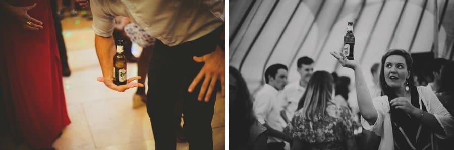 A wedding guest balances a bottle on the palm of his hand