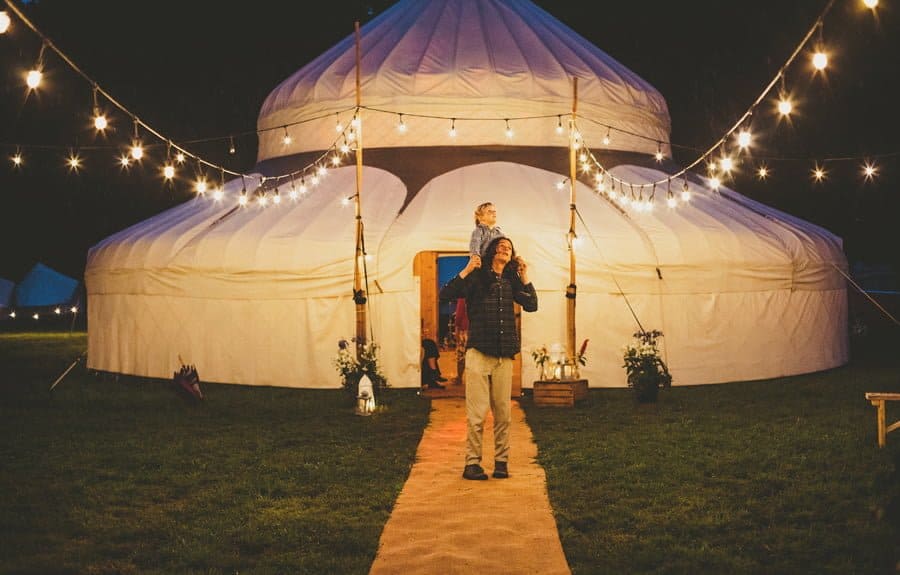 A man and his son look up into the night sky outside the yurt
