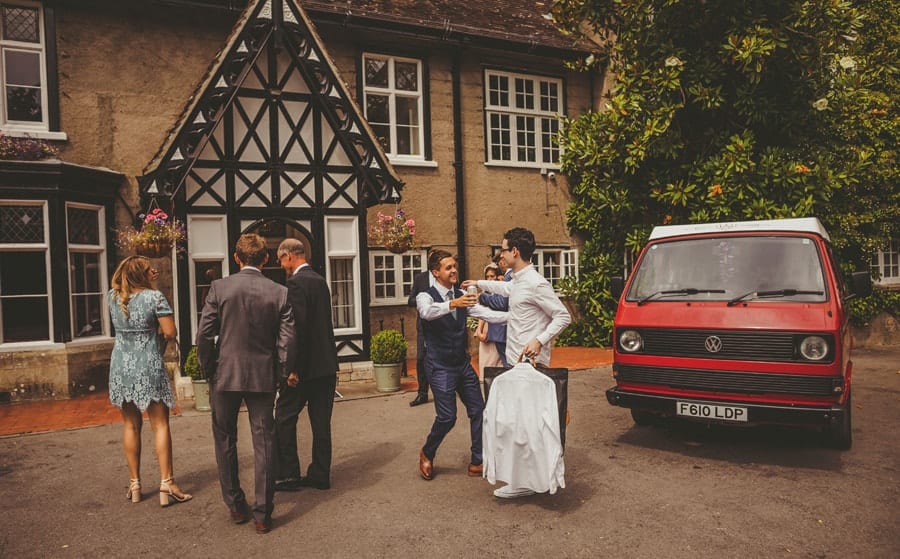 The groom greets friends and family as they arrive outside Barley Wood house