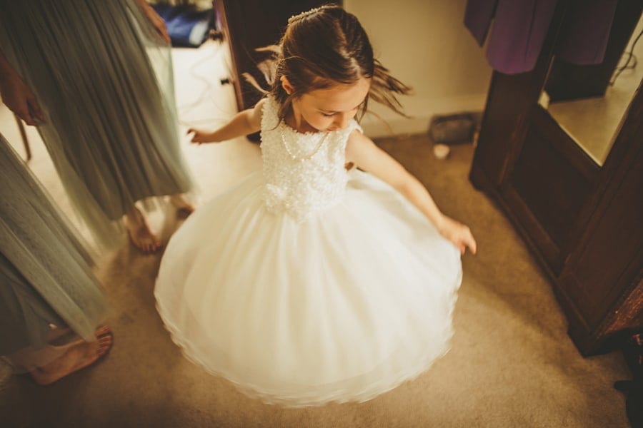 The flower girl spins around as her dress lifts up in the air