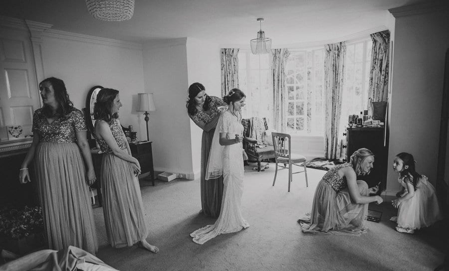 Bridesmaids getting the bride ready for her outdoor ceremony at Barley Wood house